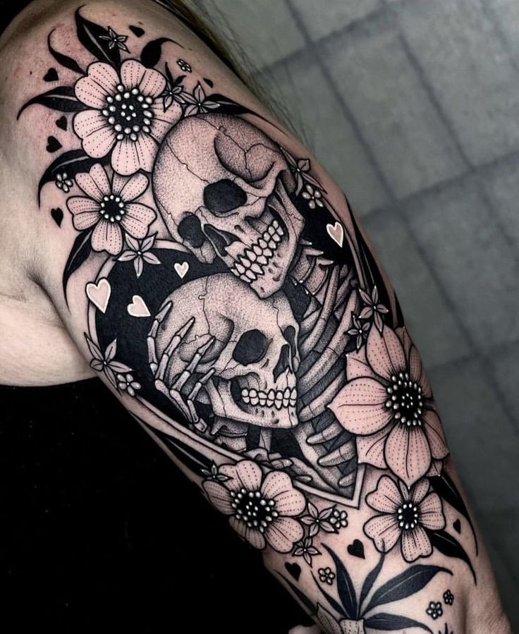 a woman's arm with a skull and flowers on it