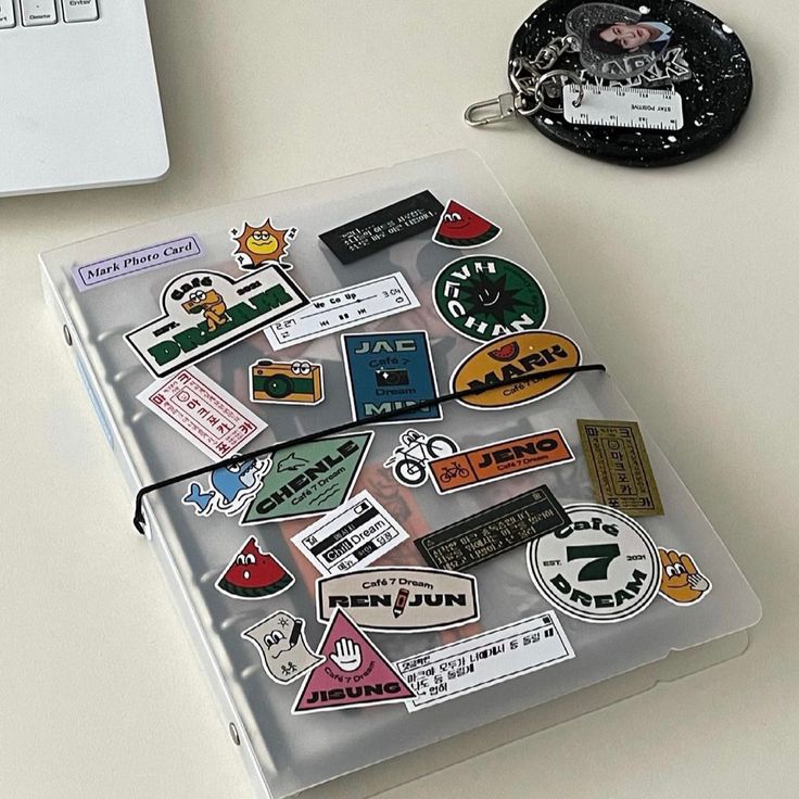 a laptop computer sitting on top of a desk next to a bunch of stickers