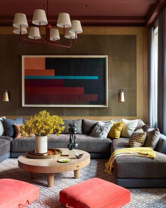 a living room filled with furniture and a painting on the wall above it's coffee table