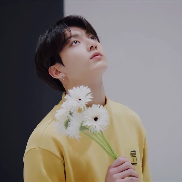 a young man holding flowers in his hands