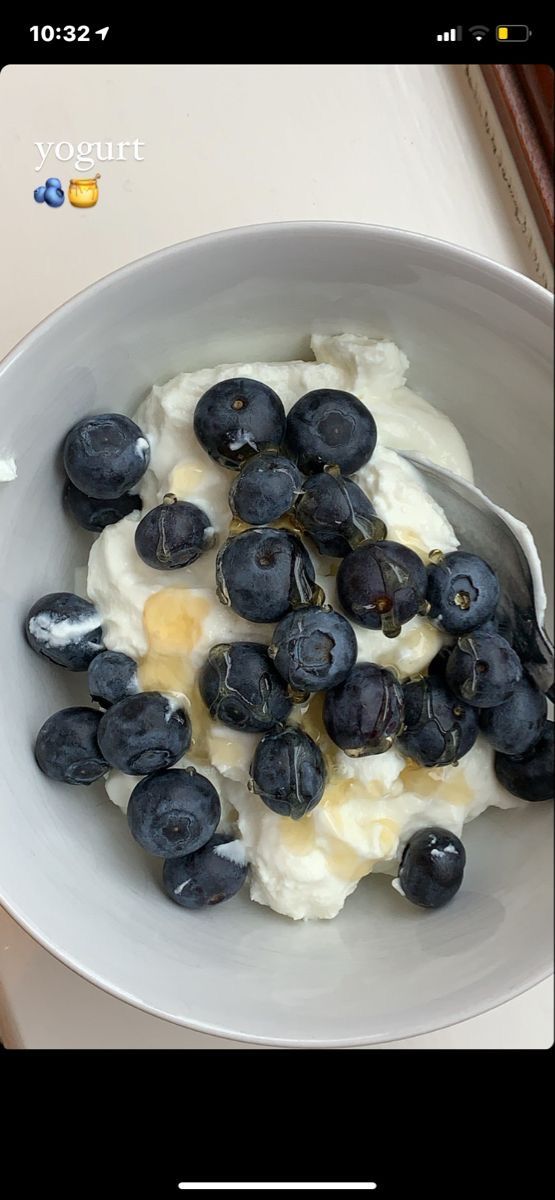 a white bowl filled with blueberries and cream