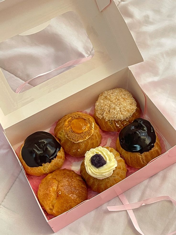 a box filled with assorted pastries on top of a bed