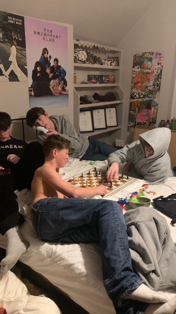 a group of young men playing chess on a bed