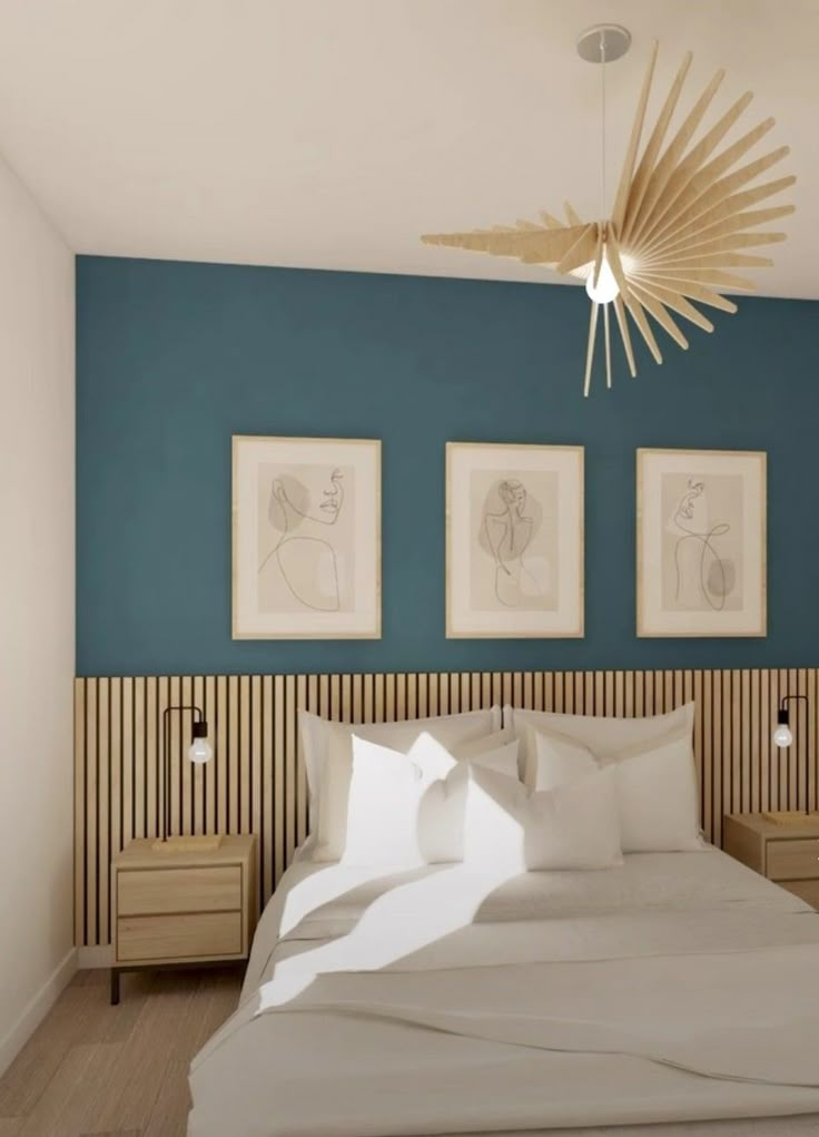 a bedroom with blue walls and artwork on the wall