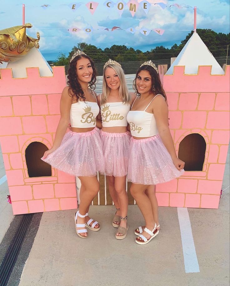 two girls standing next to each other in front of a pink castle with the words welcome home on it