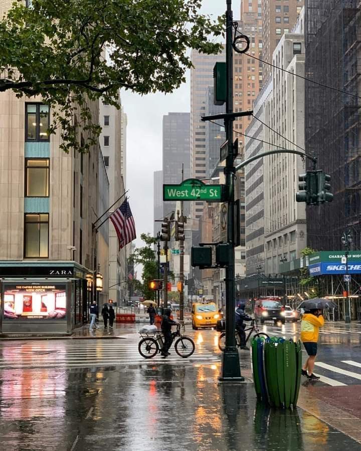 a city street filled with lots of traffic and people walking on the side of it