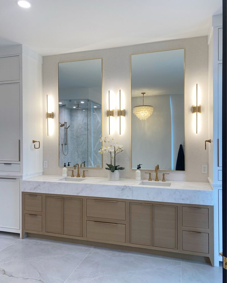 a bathroom with two sinks and three mirrors