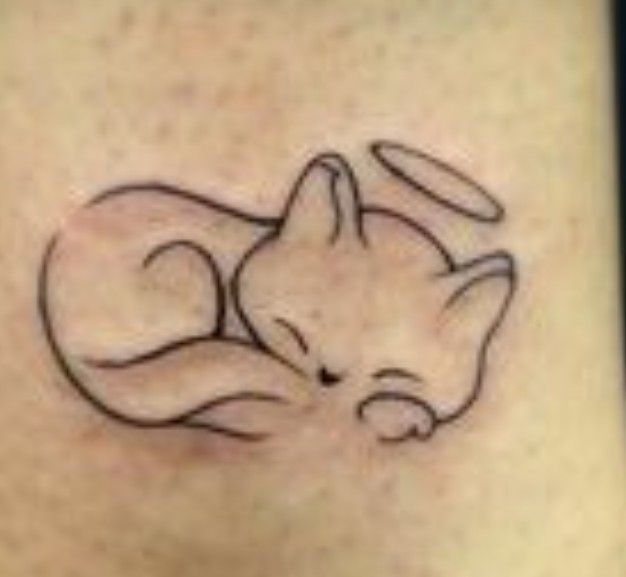 a small tattoo on the back of a woman's stomach shows a sleeping cat