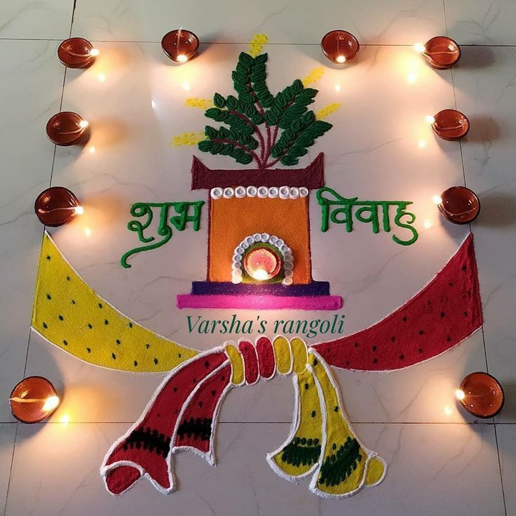 a decorated sign with lights around it on the floor in front of a wall that reads varsha's rangoli