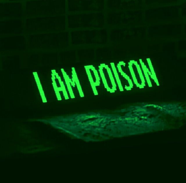 the word i am poison is projected in green light