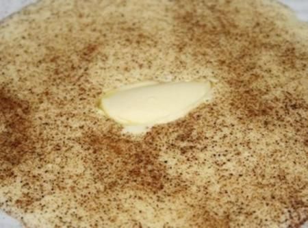 a piece of bread with butter on it sitting on top of a white table cloth