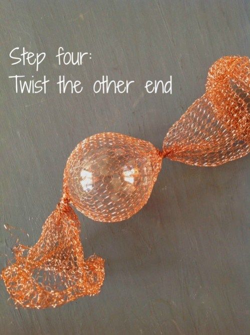 an orange string sculpture with the words step four twist the other end