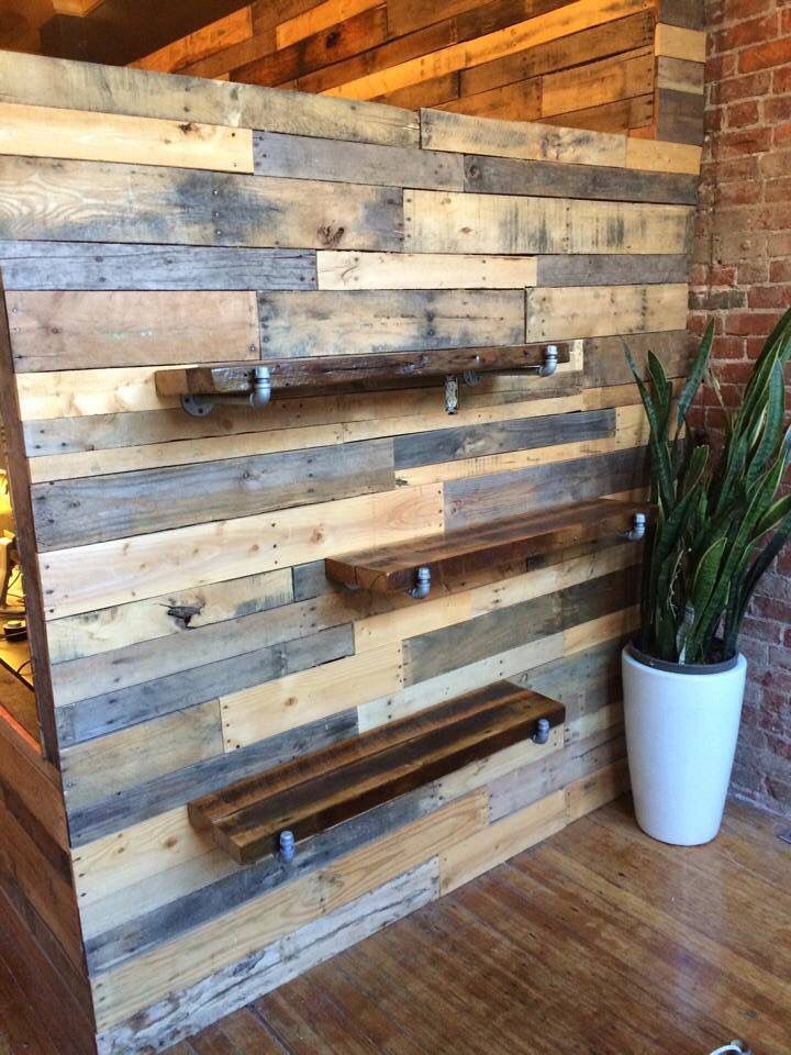 a wooden wall that has some shelves on it and a potted plant next to it