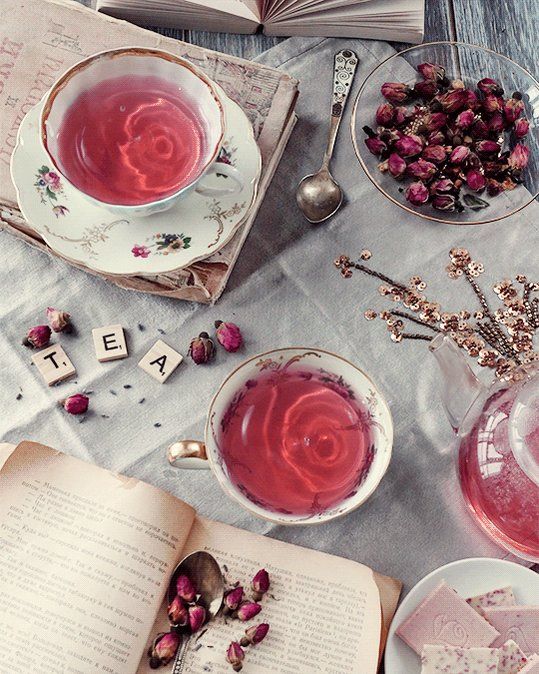 an open book and two cups of tea on a table