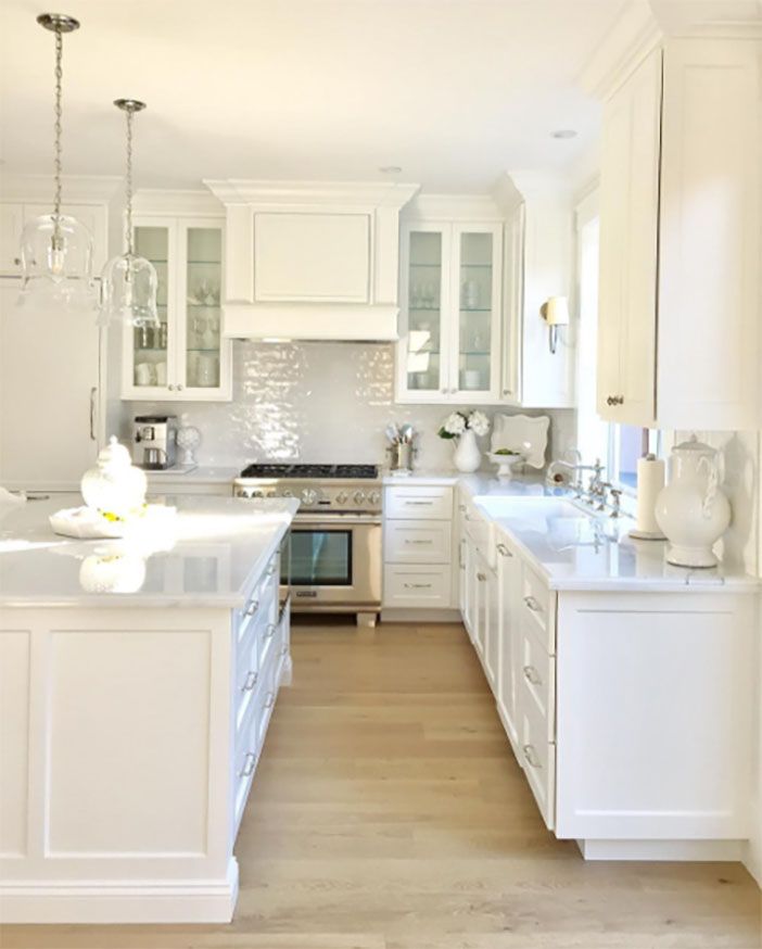 a large kitchen with white cabinets and wood flooring is pictured in this image from the front view