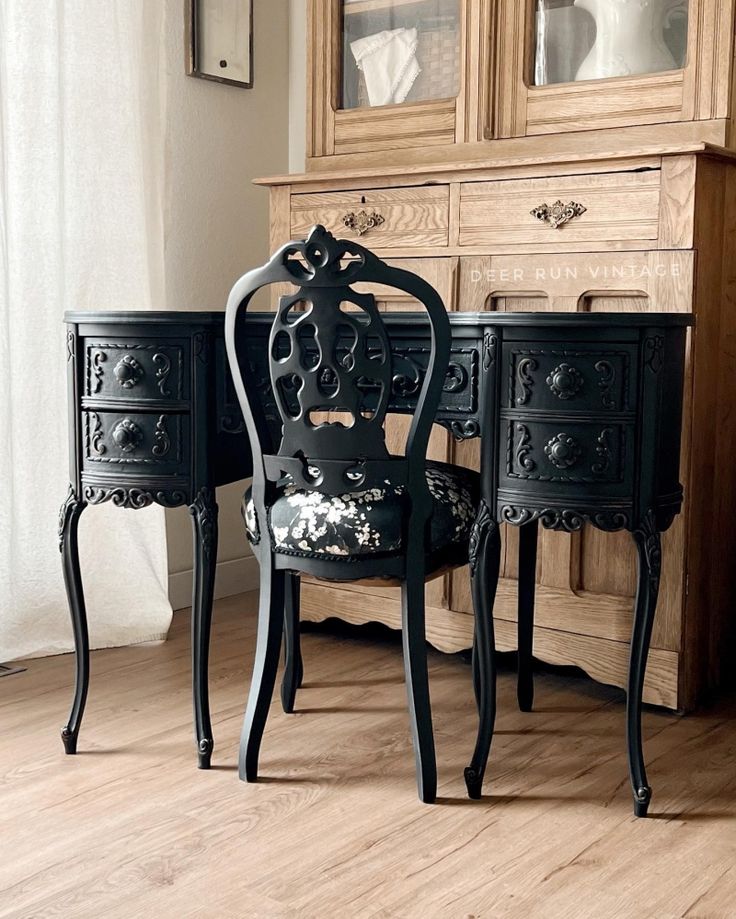 two black chairs sitting next to each other on top of a hard wood floor in front of a dresser