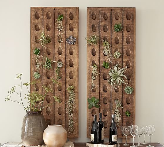 two wooden wall hangings with succulents and plants on them next to wine glasses