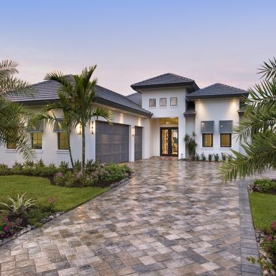 a white house with palm trees in the front yard