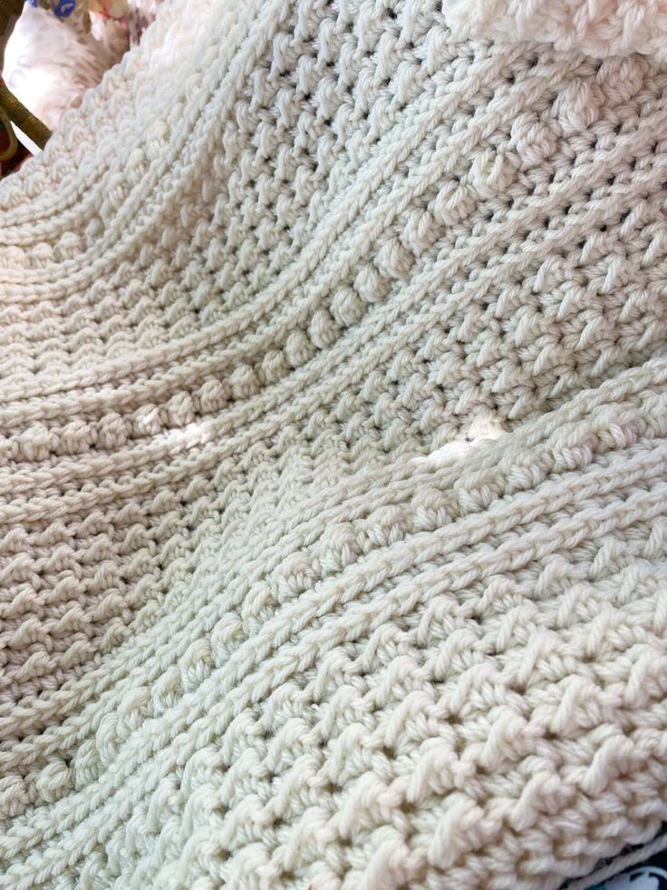 a crocheted blanket sitting on top of a bed