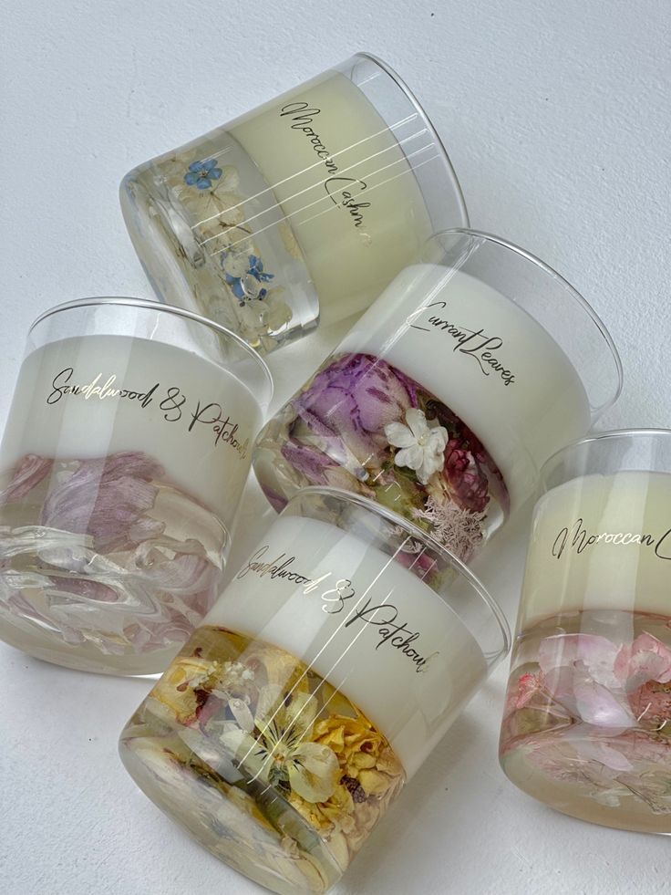 four clear cups filled with different types of flowers and words on the inside of them