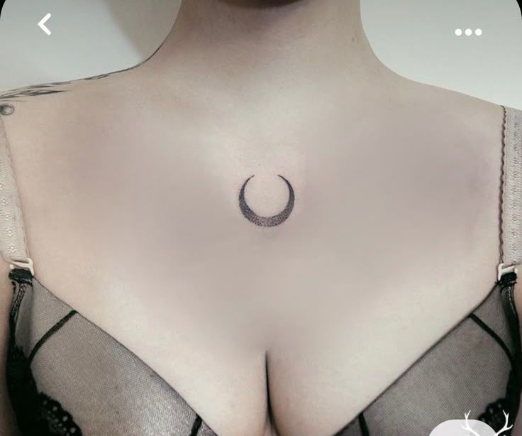 a woman's breast with a crescent tattoo on her left side, and an arrow in the middle