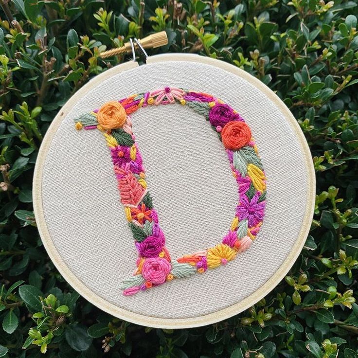 an embroidery hoop with the letter d made out of flowers