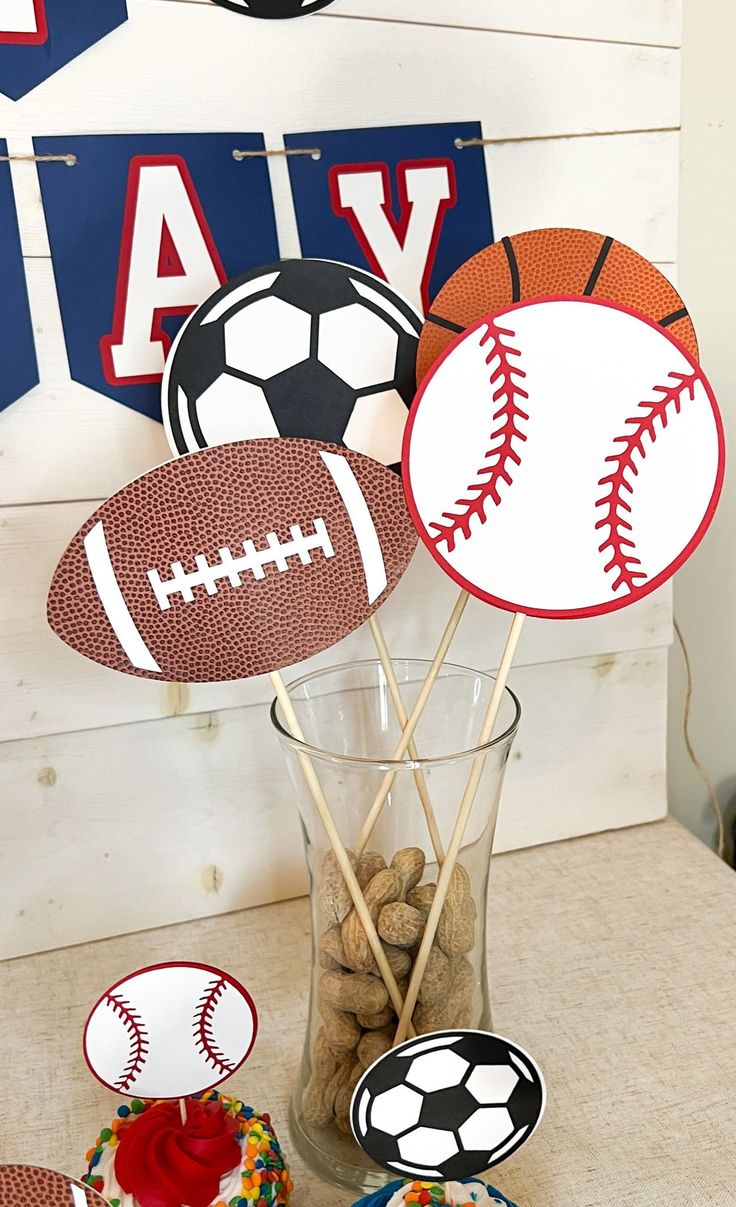 sports themed party decorations in a vase on a table