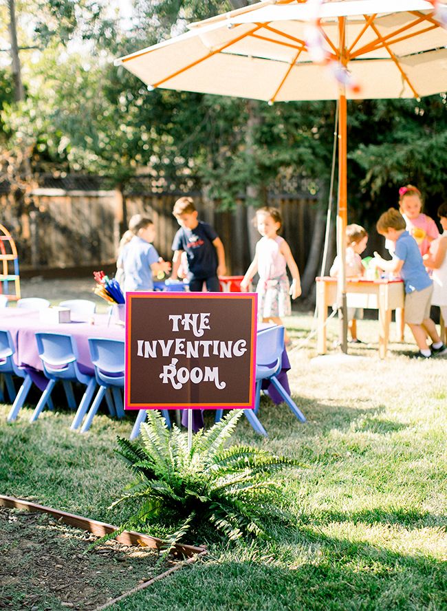 there is a sign that says true inventing room on the lawn with children around it