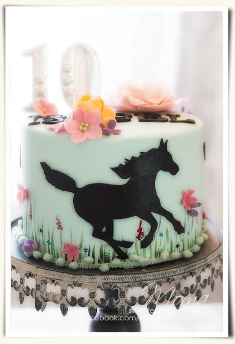 a birthday cake decorated with a horse and flowers