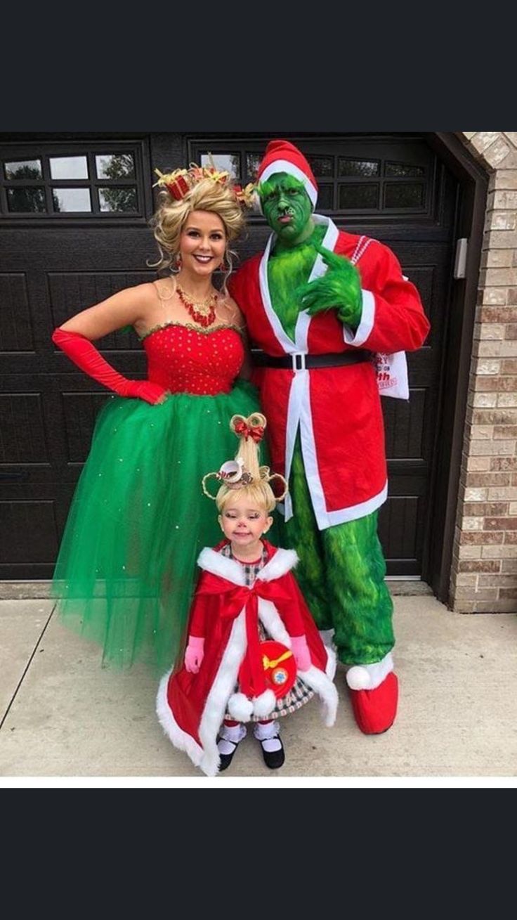 two people in costumes standing next to a child dressed up as santa and the grin