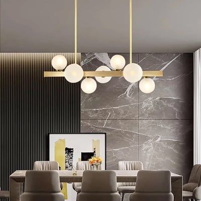 an elegant dining room with marble walls and modern lighting fixtures in gold, grey and white