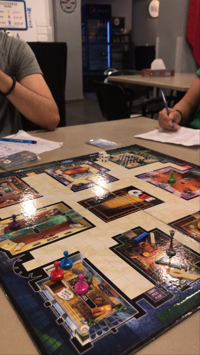 a man sitting at a table with a board game on it