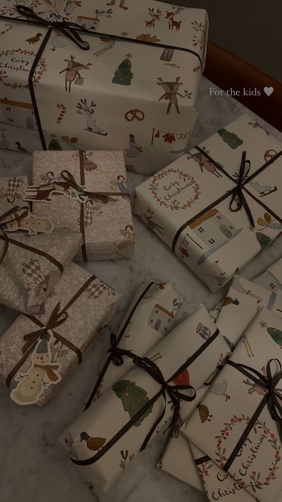 several wrapped presents sitting on top of a table next to each other with christmas designs