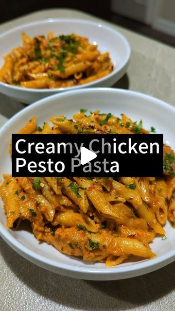 two white bowls filled with pasta covered in cheese and parsley on top of a table