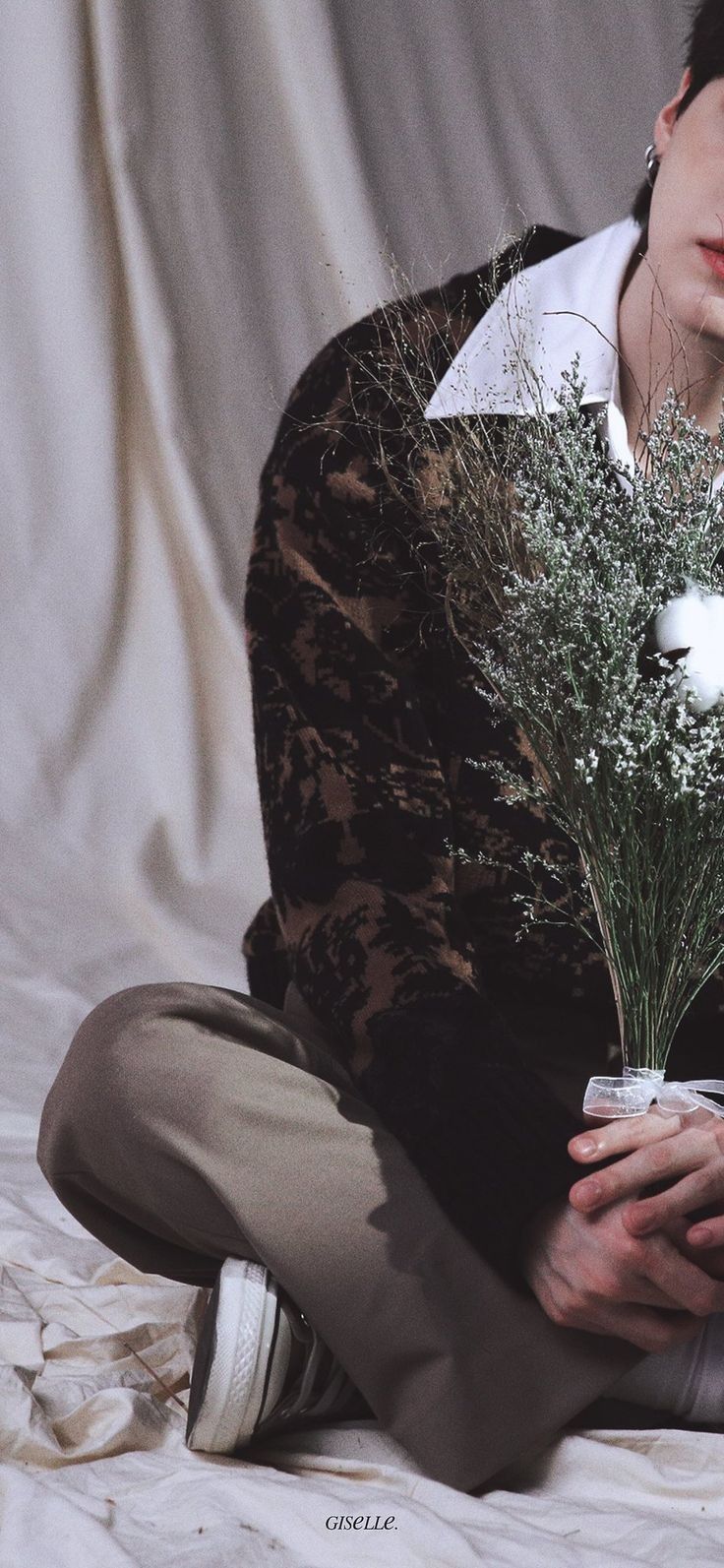 a woman sitting on the floor holding a bouquet of flowers