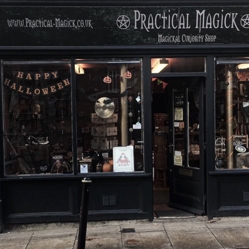 a black store front with the words practical magick on it's window display