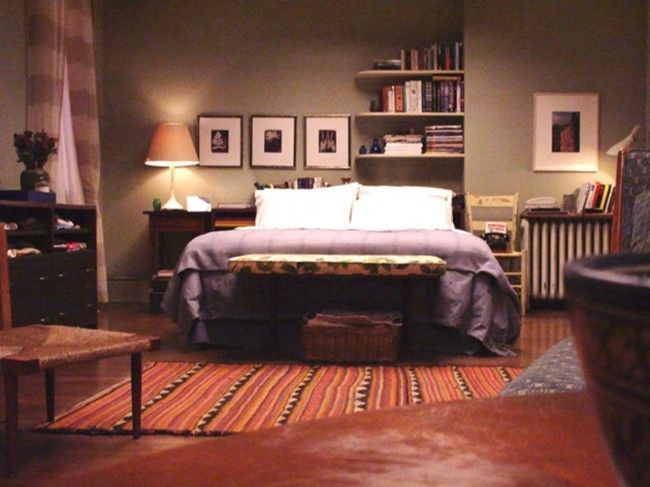 a bedroom with a bed, desk and chair in it's center area is lit by two lamps on either side of the bed