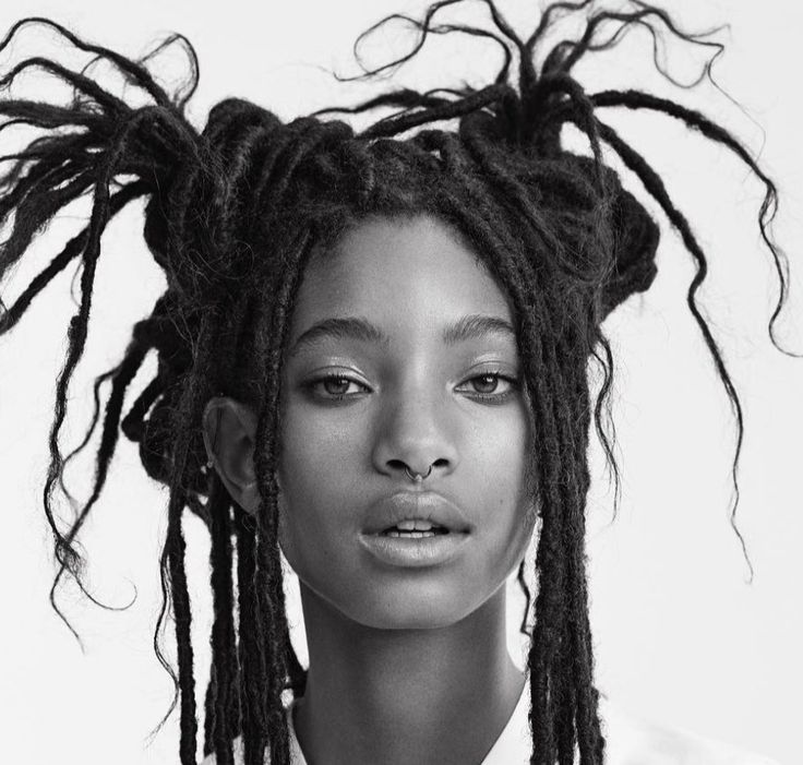 a black and white photo of a woman with dreadlocks