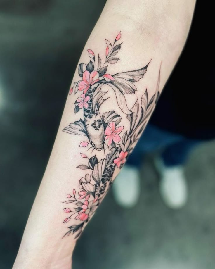 a woman's arm with flowers and leaves on it