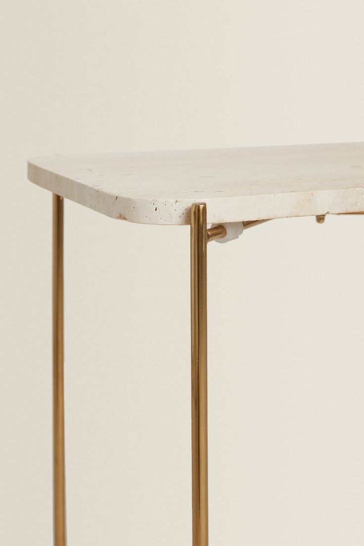 a white marble table with gold metal legs