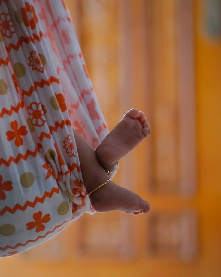 a close up of a person's foot in a hammock with flowers on it