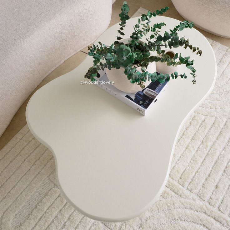 a plant is sitting on top of a white coffee table in the middle of a living room