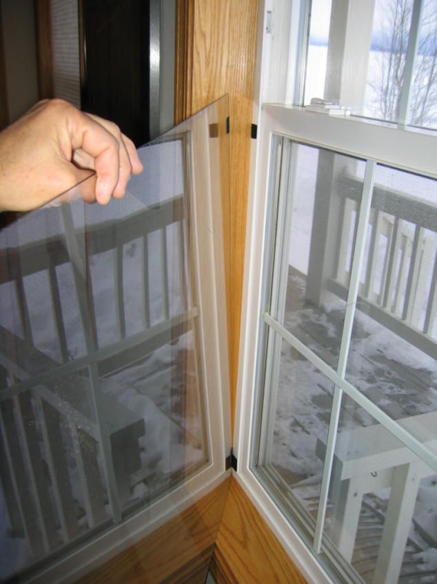 a person is holding something in their hand while looking out the window at snow outside