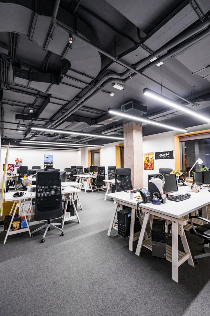 an office filled with lots of desks and computer monitors on top of each other