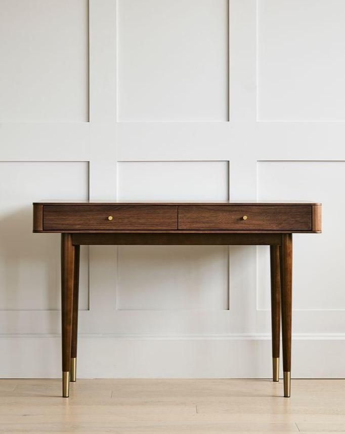 a wooden table sitting on top of a hard wood floor next to a white wall