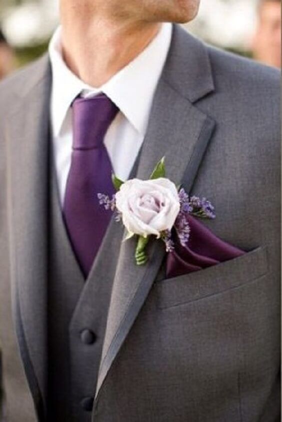 a man wearing a suit and tie with a flower in his lapel pin on his lapel