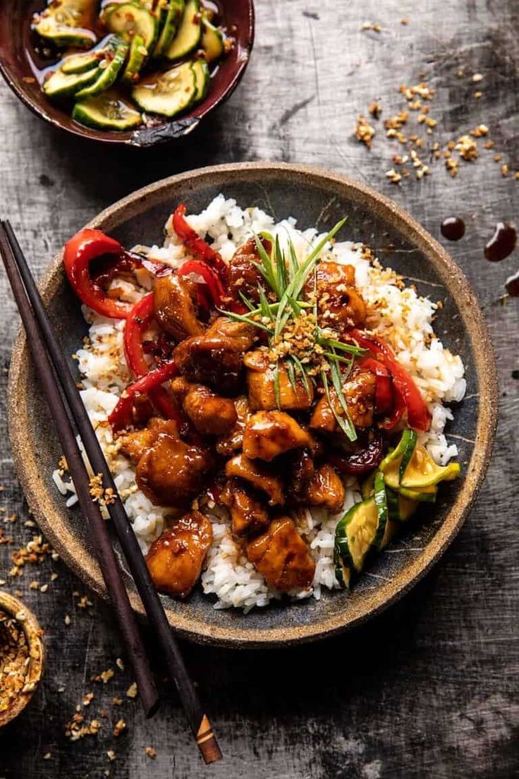 two bowls filled with food and chopsticks next to each other