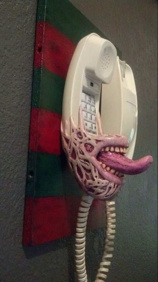 an octopus cell phone mounted to the side of a wall with it's mouth open