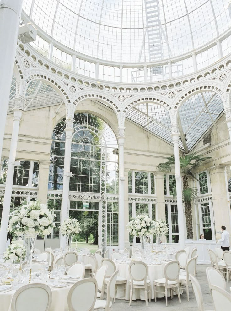 the inside of a building with tables and chairs set up for a formal function in front of large windows