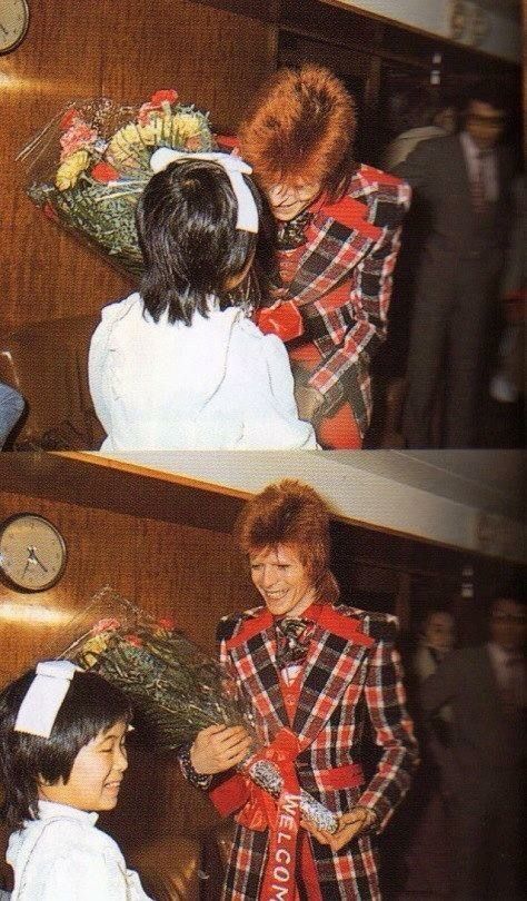 two women in plaid shirts and ties standing next to each other with wreaths on their heads